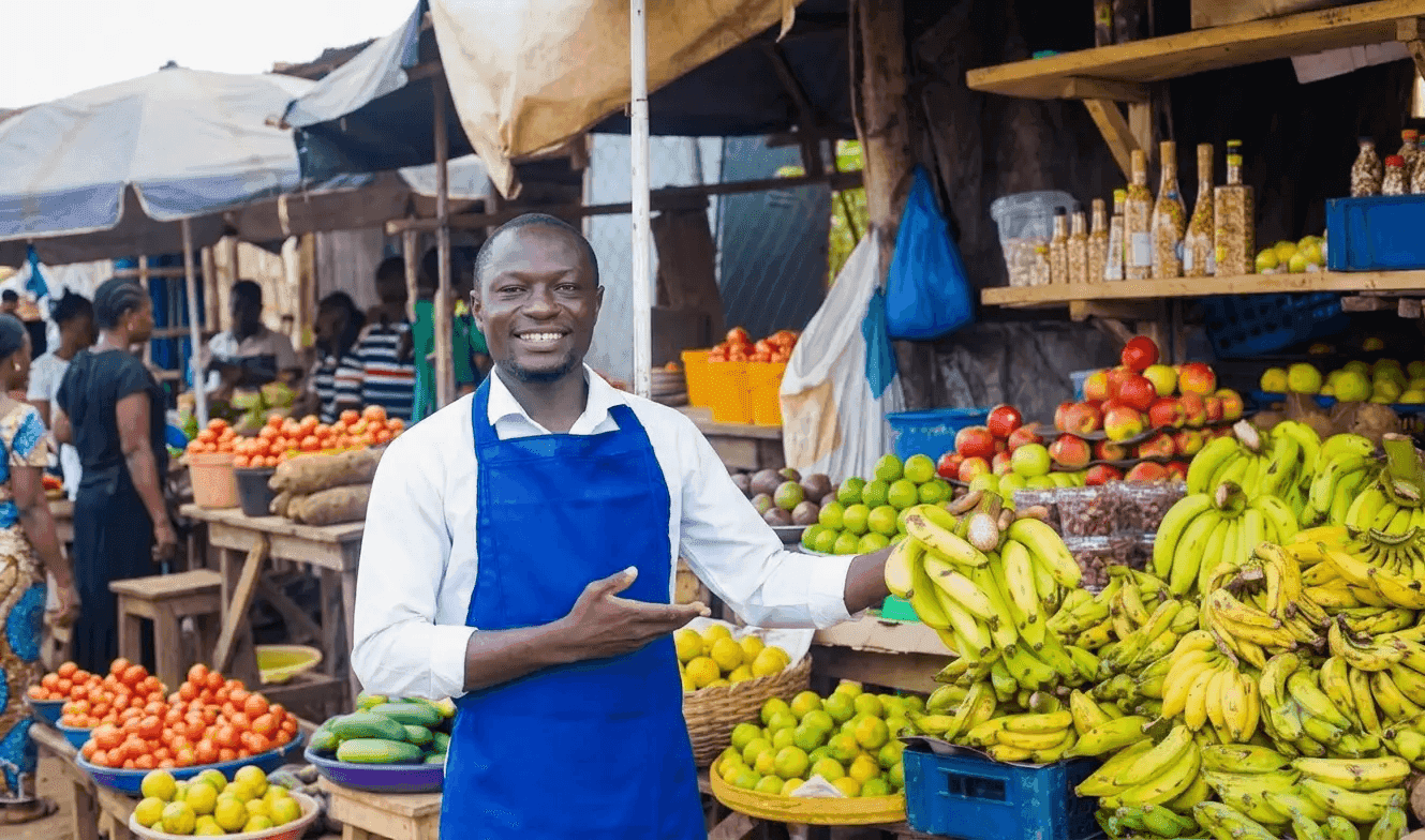 Smiling vendor at his fruit and vegetable stall in a West African market